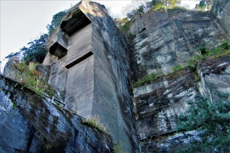 石舞台の名称がついた石切場跡。高さ100mに迫る断崖絶壁で、壁の左側面には「安全第一」の文字が刻まれている。